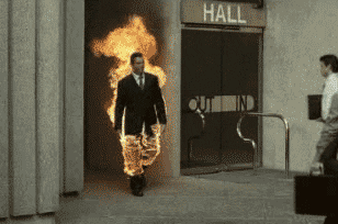 GIF of a man in a suit on fire shaking hands with another office worker